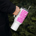 White tumbler with pink pattern held by a person against a green leafy background