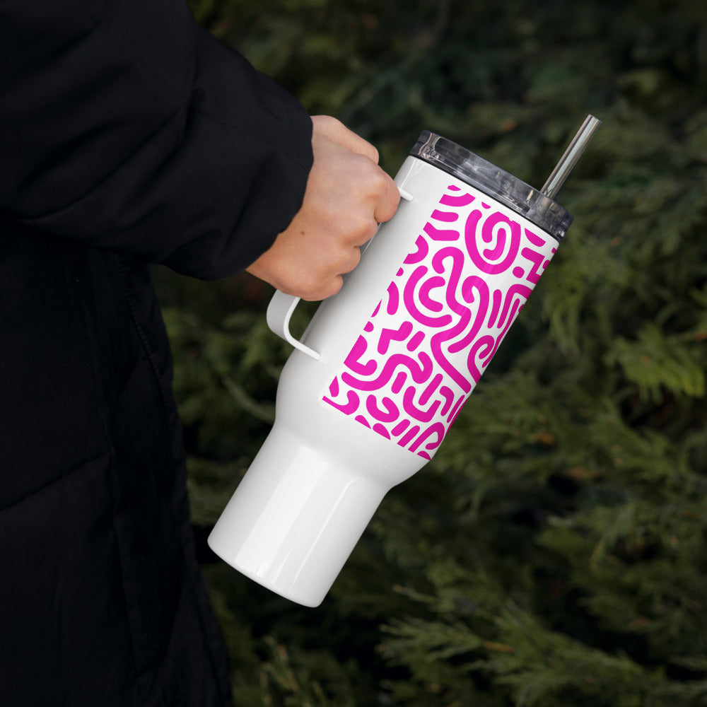 White tumbler with pink pattern held by a person against a green leafy background