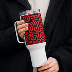 Person holding a white tumbler with a red pattern, wearing a black coat.