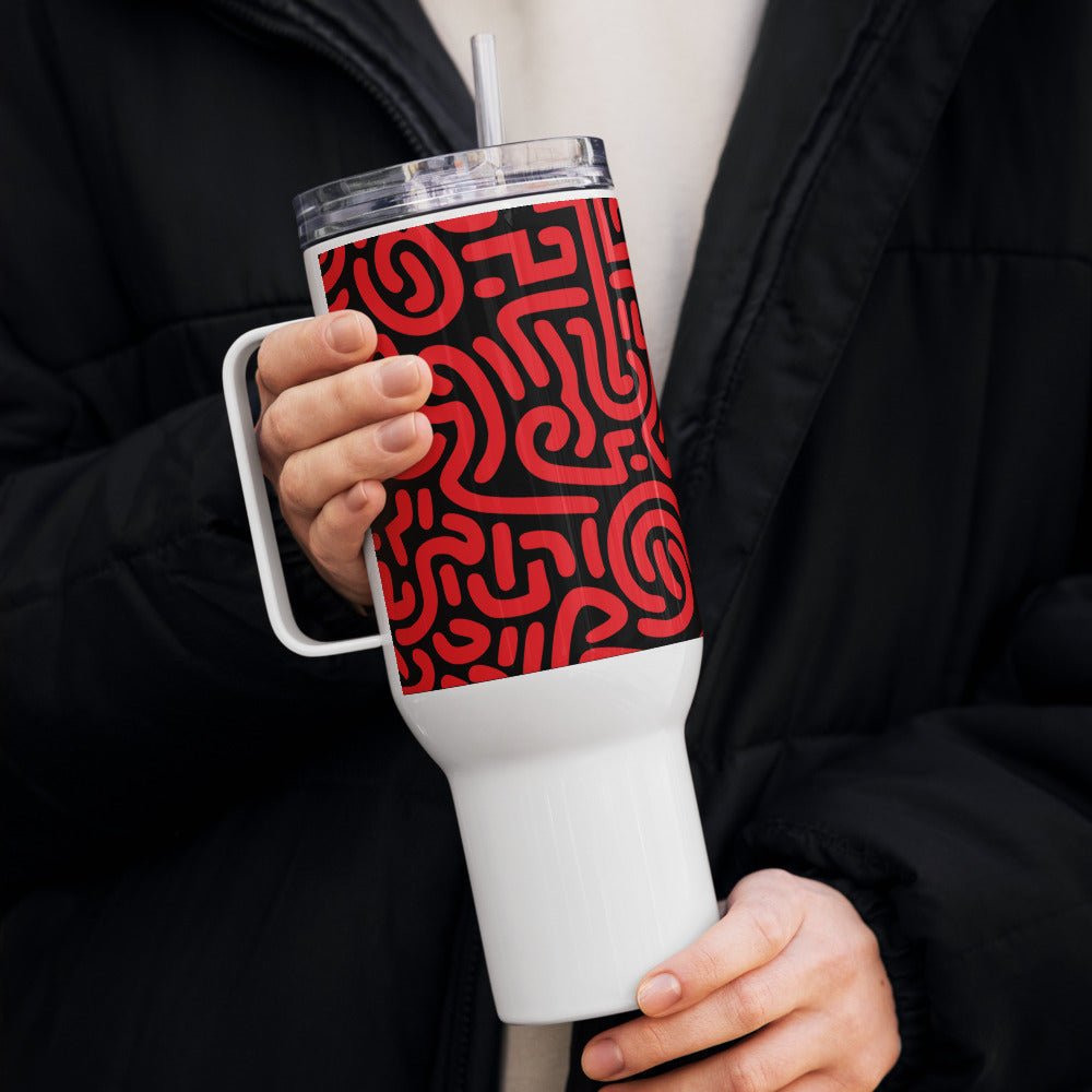 Person holding a white tumbler with a red pattern, wearing a black coat.